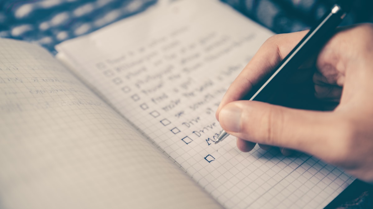A pen resting on a hand-filled checklist