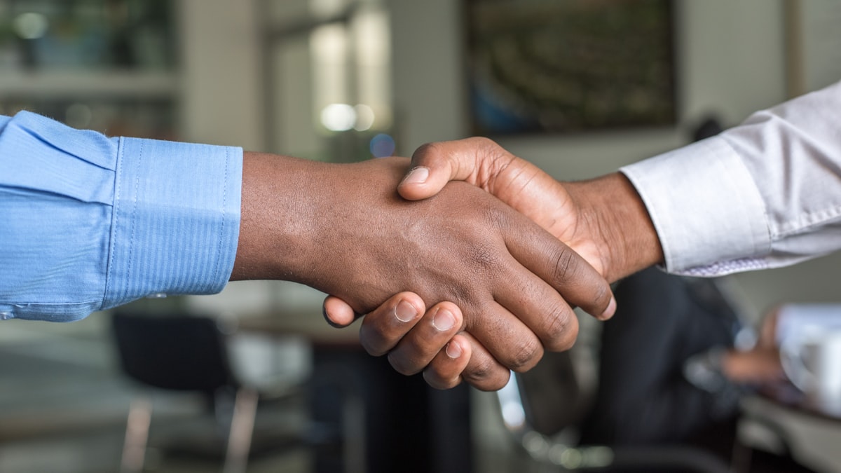 Two colleagues shaking hands on a shift swap agreement