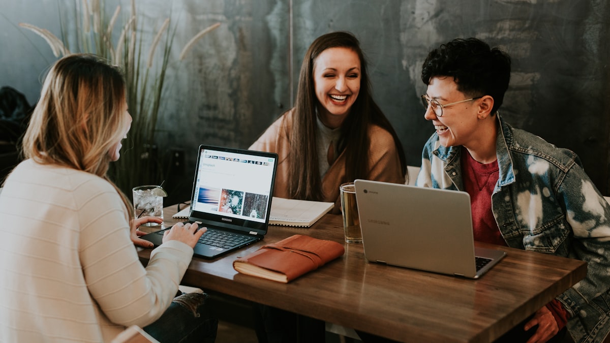 New colleague learning alongside teammates in front of a laptop