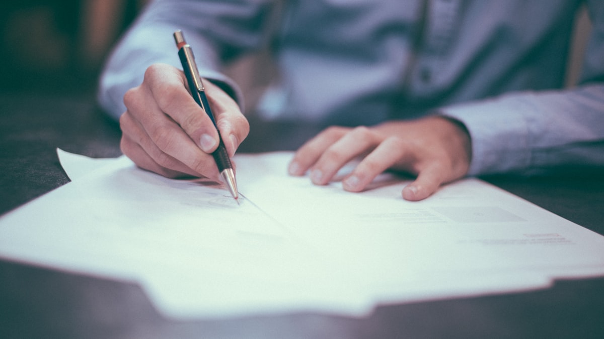 Signing contract paperwork at a desk