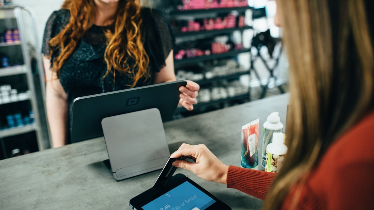 Customer at the store counter being served by staff at the till