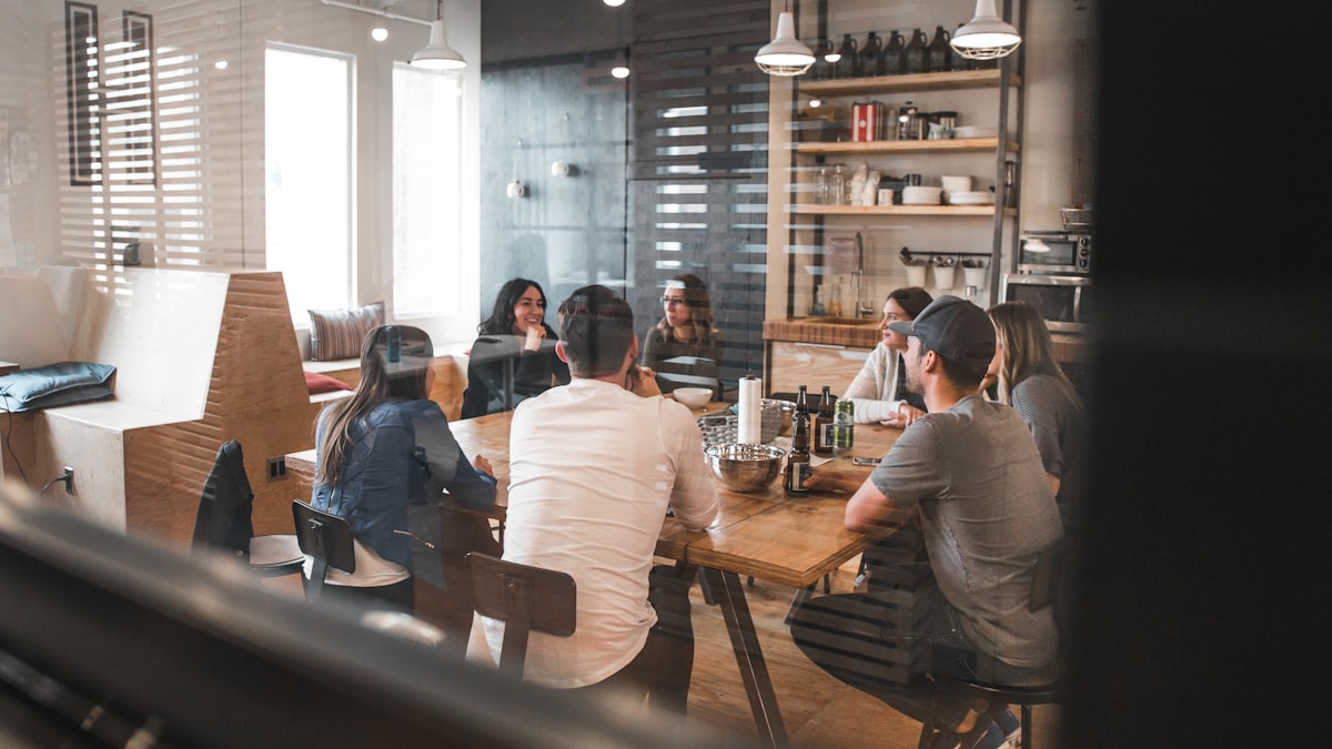 Team gathered around a table exchanging information in person